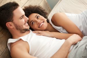 Man and woman laying in bed together clothed