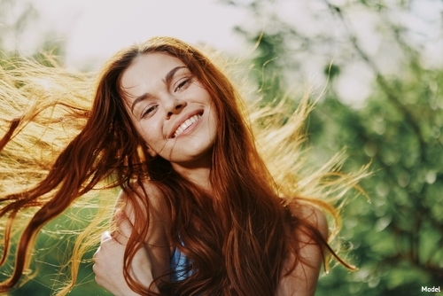woman smiling, while feeling face